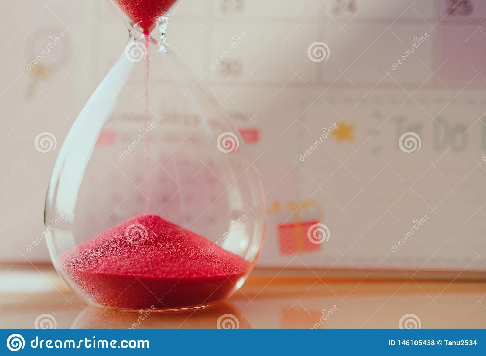 Crystal Hourglass With Red Sand On Calendar Concept For Time