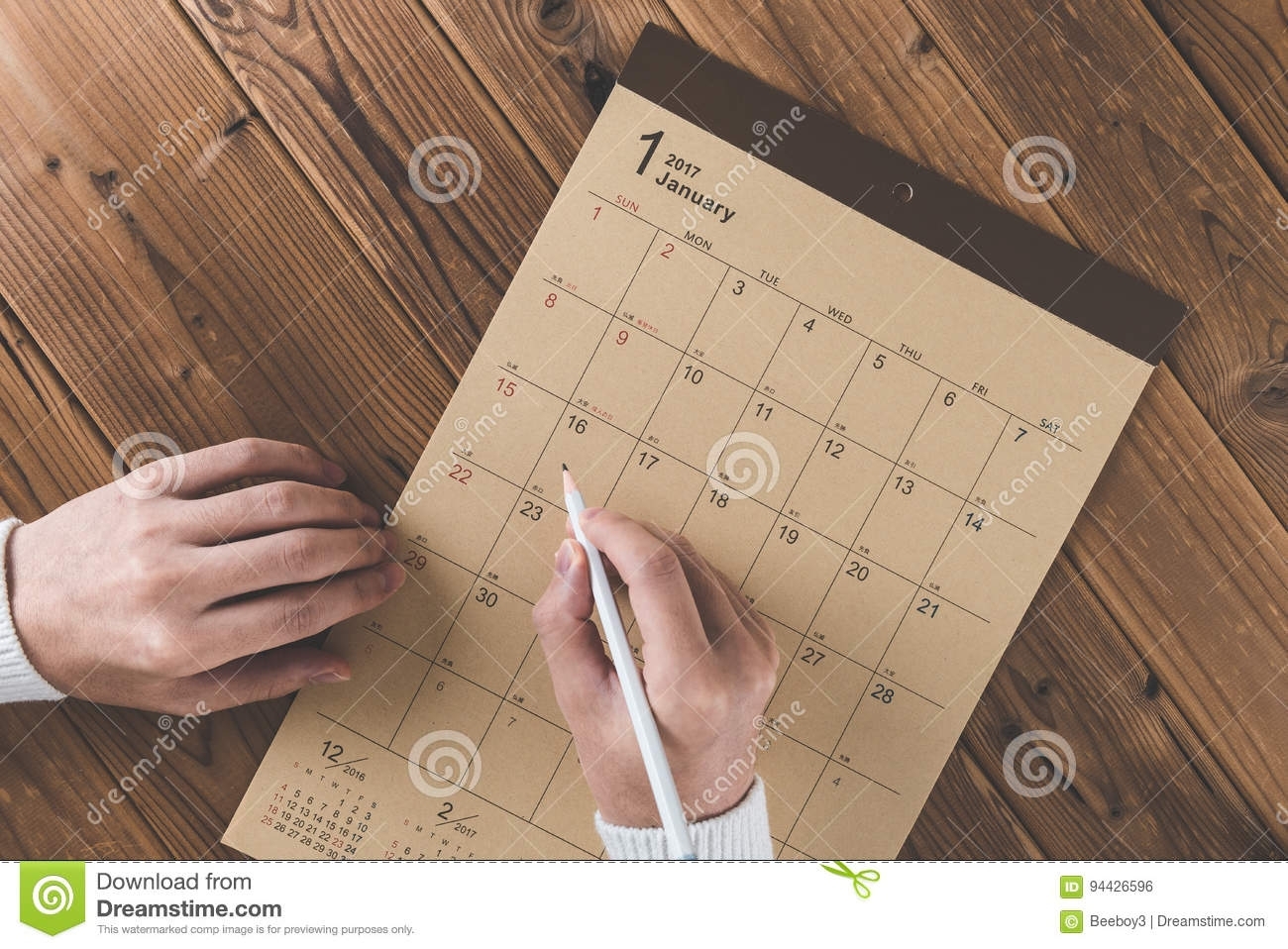 Write A Schedule To A Calendar Placed On A Wooden Table